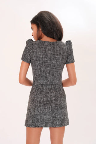 The model is wearing a grey Amelie Tweed Dress by Chloe Colette. It is showing the back side of the dress.