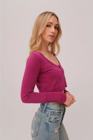 The model is wearing a fuchsia Glitz Cardi top by Chloe Colette showing the side view.