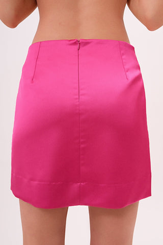 The model is wearing a satin roselite Jenny Mini Skirt by Chloe Colette showing the back side.