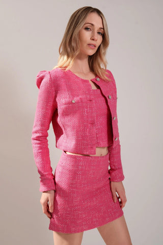 The model is wearing a full tweed outfit. Jacket and Mini skirt by Chloe Colette.