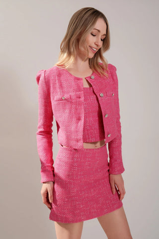 The model is wearing a full tweed outfit. Jacket and Mini skirt by Chloe Colette.