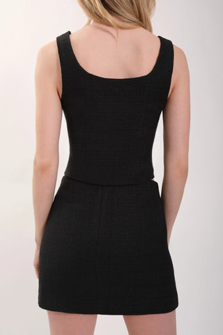 The model is wearing a black tweed Tank Top and Mini Skirt by Chloe Colette.