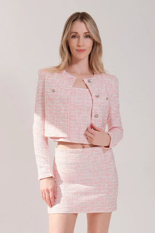 The model is wearing a Juliette tweed jacket and Jenny Tweed Mini Skirt in pink rose color by Chloe Colette.