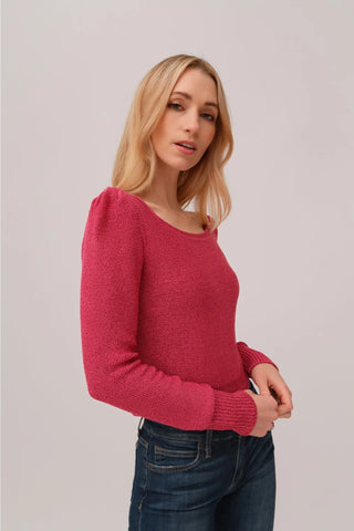 The model is wearing a fuchsia Jolie Lite knit by Chloe Colete with blue jeans.