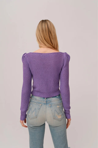 The model is wearing a purple topaz Jolie Lite-knit sweater by Chloe Colete with blue jeans showing the back side view.