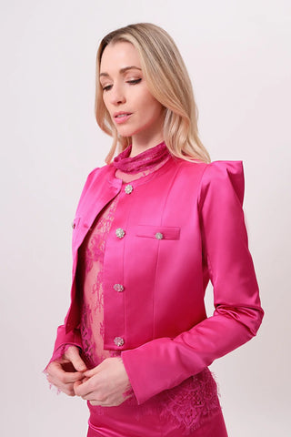 The model is wearing a Juliette Satin Jacket in rosalite and Jenny Mini Skirt by Chloe Colette.