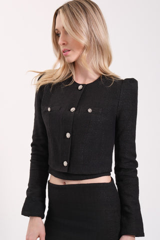 The model is wearing a black Juliette Tweed Jacket and Jenny Tweed Mini Skirt by Chloe Colette.