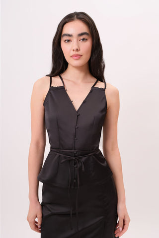 The model is wearing a black tourmaline Mykonos Satin Top and Jenny Mini Skirt by Chloe Colette.