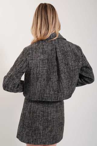 The model is wearing a black opal Vivienne Tweed Jacket by Chloe Colette.