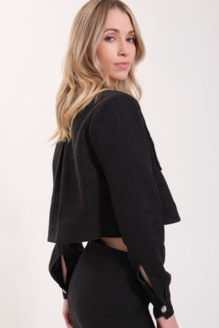 The model is wearing a black noir Vivienne Tweed Jacket by Chloe Colette.