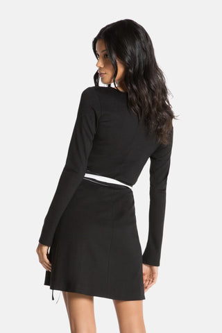 Model is wearing a black mini dress Edith by Chloe Colette.