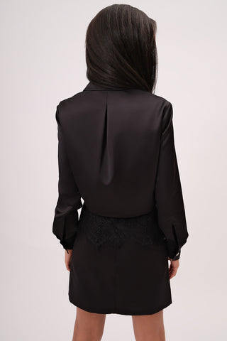 The model is wearing a black tourmaline Vivienne Satin Jacket by Chloe Colette.