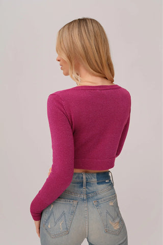 The model is wearing a fuchsia Glitz Cardi top by Chloe Colette showing the back side.