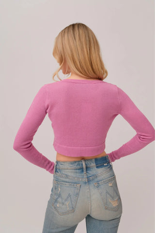 The model is wearing a rose quartz Glitz Cardi top by Chloe Colette showing the back side.