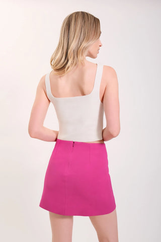 The model is wearing a white Anjelike Tank Top and matte fuchsia Jenny Mini Skirt by Chloe Colette.