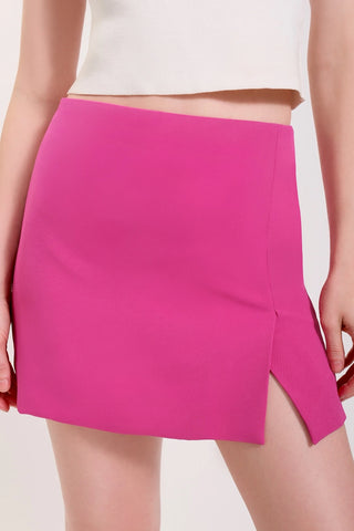 The model is wearing a matte fuchsia Jenny Mini Skirt by Chloe Colette showing the front side.