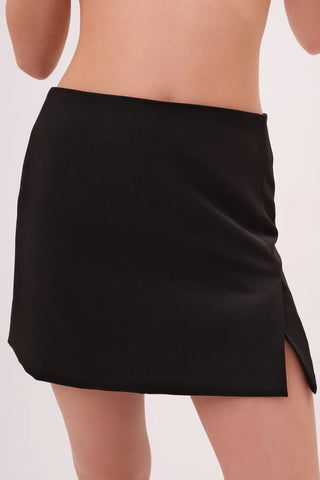 Model wearing a black Jenny Satin Slit Mini Skirt by Chloe Colette showing the front side.