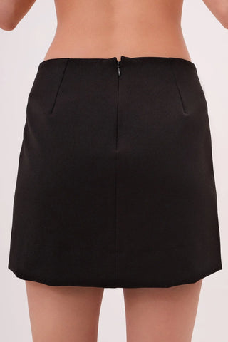 Model wearing a black Jenny Satin Slit Mini Skirt by Chloe Colette showing the back side.