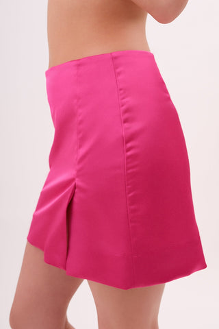 The model is wearing a satin roselite Jenny Mini Skirt by Chloe Colette showing the side view.