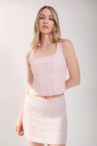 The model is wearing a pink rose Tweed Tank Top and Jenny Tweed Mini Skirt by Chloe Colette showing the front side view.
