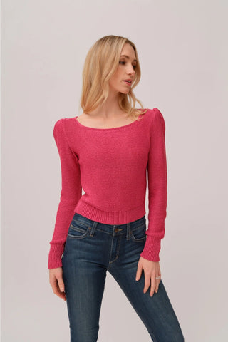 The model is wearing a fuchsia Jolie Lite knit by Chloe Colete with blue jeans.