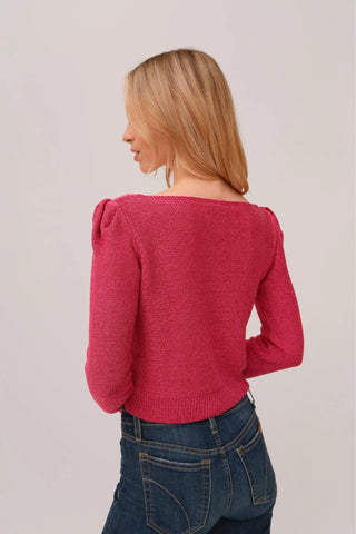 The model is wearing a fuchsia Jolie Lite-knit sweater by Chloe Colete with blue jeans showing the back side view.