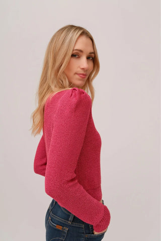 The model is wearing a fuchsia Jolie Lite-knit sweater by Chloe Colette with blue jeans.