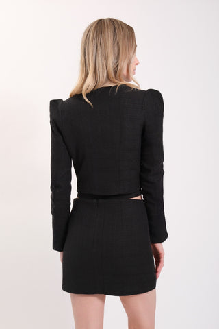The model is wearing a black Juliette Tweed Jacket and Jenny Tweed Mini Skirt by Chloe Colette.