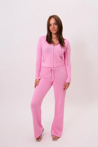 Model is wearing a candy pink Malibu Zip Up Hoodie and Cord Pants by Chloe Colette.