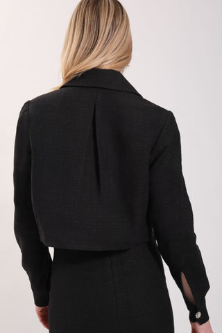 The model is wearing a black noir Vivienne Tweed Jacket by Chloe Colette.