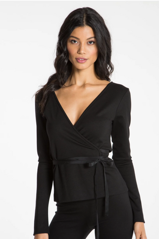 Model is wearing an black Sydney wrap cardigan by Chloe Colette.