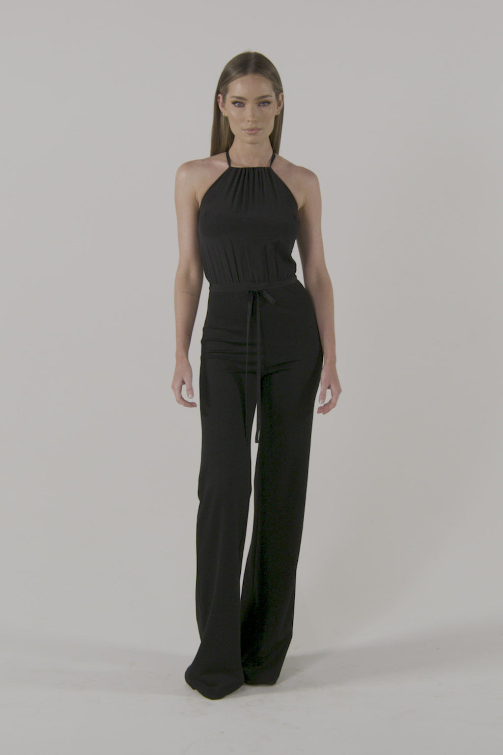 Model is wearing a black Starla Jumpsuit by Chloe Colette